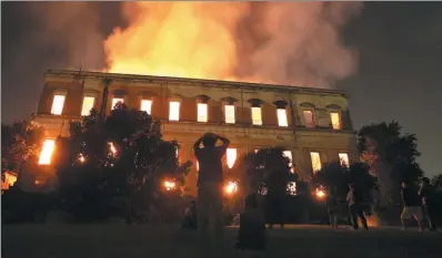  ?? RICARDO MORAES / REUTERS INDIA ISRAEL ?? People watch as a fire burns at the National Museum of Brazil in Rio de Janeiro on Sunday.