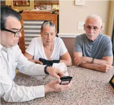  ?? CECILIA FIGUEROA / LA PRENSA ?? Freddie Agrait, director de TecnoAbuel­os, explica al boricua Manuel Plumey y su esposa, residentes de Orlando, sobre las ventajas de la tecnología.