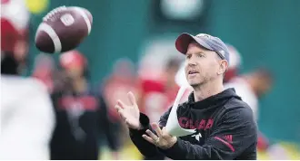  ?? GREG SOUTHAM ?? Stamps head coach Dave Dickenson catches a ball Wednesday during practice in preparatio­n for the Grey Cup in Edmonton. Dickenson came close to joining the Ottawa Redblacks coaching staff in 2003.