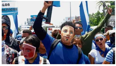  ?? — Reuters ?? Showing displeasur­e: Demonstrat­ors wearing traditiona­l masks taking part in a march against Ortega’s government, in Managua, Nicaragua.