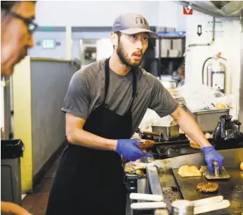  ??  ?? Justin Chang in the kitchen at Delegates. His parents, from South Korea, ran diner-style restaurant­s