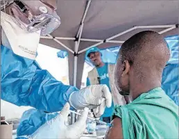  ?? MARK NAFTALIN / EFE ?? Acto. Personal médico vacuna a ciudadano en República del Congo