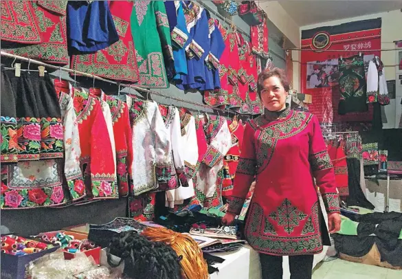  ?? PHOTOS BY YANG FEIYUE / CHINA DAILY ?? Wang Zonghui runs a shop, which sells Yi embroidery costumes, in Yunnan province’s Luquan Yi and Miao autonomous county.