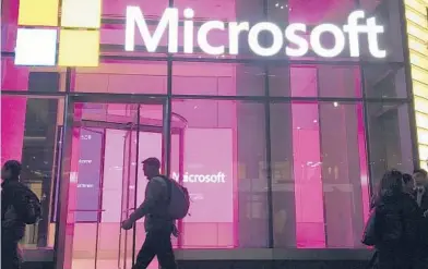  ?? SWAYNE B. HALL/AP 2016 ?? China-based government hackers have exploited a bug in Microsoft’s email server software to target U.S. organizati­ons, the company said. The White House has called the hack an“active threat.”Above, people walk past a Microsoft office in New York.