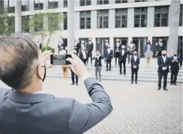  ??  ?? 0 German foreign minister Heiko Maas takes a picture of EU colleagues as they pose for a ‘ family photo’