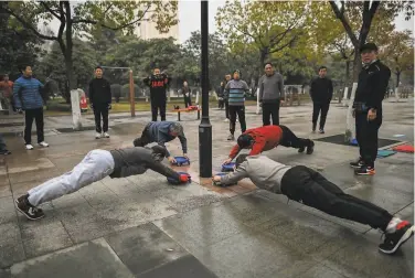  ?? Hector Retamal / AFP / Getty Images ?? Residents exercise in a park in Wuhan one year after the city went into lockdown to curb the spread of the coronaviru­s. Life has largely returned to normal in the city of 11 million in China’s central Hubei province.