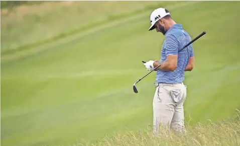  ?? PHOTOS BY MICHAEL MADRID, USA TODAY SPORTS ?? Dustin Johnson takes a break to look at his cellphone during a U. S. Open practice round Wednesday at Erin Hills in Wisconsin.