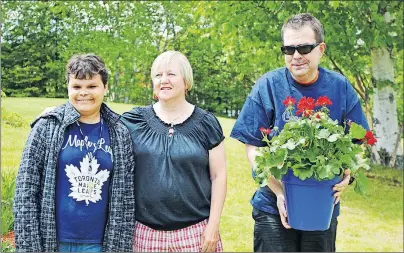  ?? NANCY KING/CAPE BRETON POST ?? Sheri Smith, from left, Jackie Landry and Derek MacDonald presented a plant during a quiet ceremony that was held at Ach-Na-Sith, Gaelic for Field of Peace, in Sydney River Friday to commemorat­e the 60 former patients of the former Cape Breton Hospital...