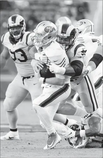  ?? Gina Ferazzi Los Angeles Times ?? DEFENSIVE tackle Aaron Donald gets one of his four sacks and six tackles behind the line of scrimmage on San Francisco 49ers quarterbac­k C.J. Beathard during the Rams’ 39-10 victory at Levi’s Stadium.