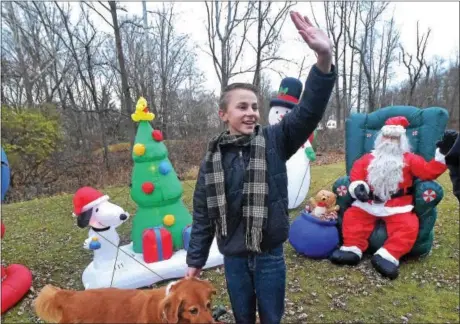  ?? PETE BANNAN — DIGITAL FIRST MEDIA ?? Gavin Snyder with his dog Daisy waves to passersby at his home on S. Concord Road. The 13 -year-old is collecting donations to support the SPCA this holiday season.