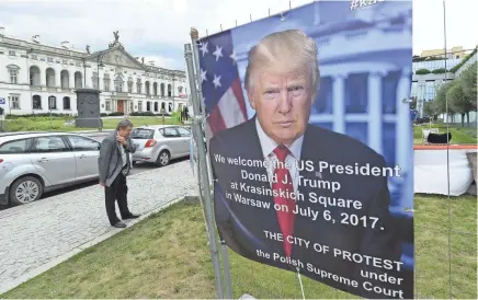  ??  ?? A poster advertises President Donald Trump’s visit Thursday to Warsaw, Poland. Trump will meet Russian President Vladimir Putin for the first time later in the week.