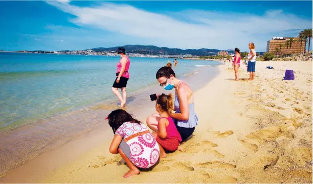  ?? Agence France-presse ?? ↑
People enjoy a beach day at Can Pere Antoni Beach in Palma de Mallorca on Monday, on the first day after beaches reopened in Spain after months-long closures.