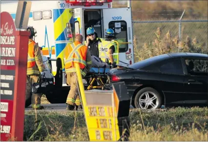  ?? JASON KRYK/The Windsor Star ?? A victim is loaded onto an ambulance following a crash at County Road 42 and the 8th Concession near Windsor Airport on Thursday. A young boy was transferre­d to hospital in Detroit with head injuries.