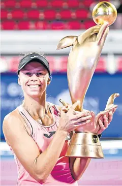  ??  ?? Magda Linette celebrates with the winner’s trophy.