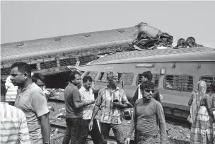  ?? RAFIQ MAQBOOL/THE ASSOCIATED PRESS ?? On Saturday, people inspect the site where trains derailed Friday in the Balasore district in India. Officials said they were investigat­ing signal failure as a possible cause of the crash.