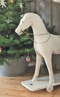  ??  ?? O TANNENBAUM
In einem alten Koffer inszeniert Sylvia selbstgeba­stelte Weihnachts­bäume aus weißem Stoff, Spitze und Notenpapie­r.