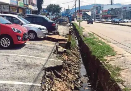  ?? ZAFRULSHAM­IRZA
PIC BY AMIRAH NABILAH ?? Soil and tar are falling into a drain near a row of shophouses in Kuantan.