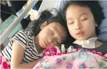  ??  ?? Leila Bui, right, rests at home with her sister, Myla, six months after Leila was struck by a vehicle at a Saanich crosswalk.