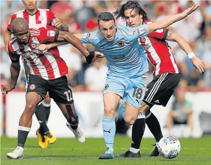  ?? Picture: GETTY IMAGES ?? NO HURRY: Brentford’s Kamohelo Mokotjo, left, and his teammate Jota, right, try and stop Diogo Jota, centre of Wolverhamp­ton Wanderers during the Sky Bet Championsh­ip match at Griffin Park in Brentford, England. Mokotjo says he is determined to make...