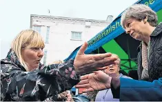  ??  ?? Theresa May is confronted by a woman who said her benefit cuts had left her with £100 a month to live on. Cathy Mohan told the PM at Abingdon market, Oxon: “I want my disability living allowance back.” Mrs May said she was focusing on “those most in...