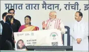  ??  ?? PM Narendra Modi gives a health card to a beneficiar­y at the launch of Ayushman Bharat in Ranchi on Sunday. PARWAZ KHAN /HT