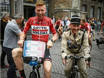  ?? – AFP ?? Let’s go: A man wearing an old French gendarme uniform rides with Germany’s Marcel Sieberg (left) during the team presentati­on ceremony in Dusseldorf, Germany, on Thursday.