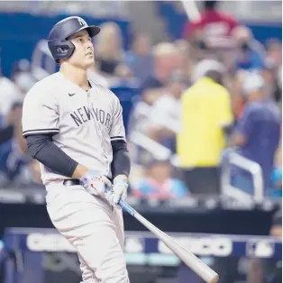  ?? LYNNE SLADKY/AP PHOTOS ?? The Yankees’ Anthony Rizzo watches after hitting a solo home run during the sixth inning against the Marlins on Friday in Miami. Rizzo was acquired from the Cubs just a day earlier.