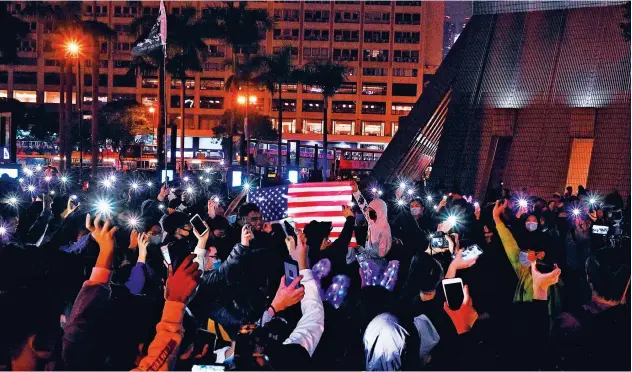  ?? Agence France-presse ?? ↑ Pro-democracy protesters take part in a march along the promenade of Tsim Sha Tsui district in Hong Kong on Tuesday.