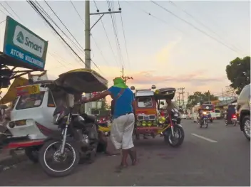  ?? SUNSTAR FOTO / ALLAN CUIZON ?? ROAD BLOCKS. DPWH says it will clear national highways of any form of obstructio­n, like these tricycles in Talisay that use a portion of the highway as their parking area.