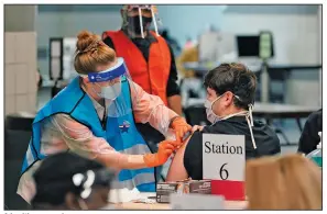  ?? (AP/Eric Gay) ?? A health care worker administer­s a covid-19 vaccinatio­n Monday at the Alamodome in San Antonio. Officials say the site is providing 1,500 vaccinatio­ns per day.