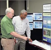  ?? Doug Walker / Rome News-Tribune ?? Brian Shoun (left) and Haydn Blaize review some documents during a public meeting in Rome Wednesday to discuss new flood hazard maps for the Etowah River Basin.