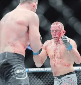  ?? ASSOCIATED PRESS FILE PHOTO ?? Georges St-Pierre, right, battles Michael Bisping during a middleweig­ht UFC title bout Nov. 5, 2017, in New York. Despite looking the worse for wear, St-Pierre won the fight.