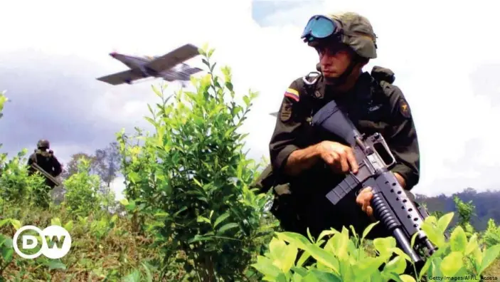  ??  ?? Soldados vigilan desde tierra la fumigación aérea con glifosato en Barbacoas, Colombia. Imagen del 12 de septiembre del año 2000