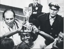  ??  ?? 0 Pele lifts the Jules Rimet trophy after Brazil beat Italy in Mexico City in the World Cup final on this day in 1970