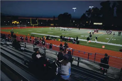  ?? PHOTOS BY ANDA CHU — BAY AREA NEWS GROUP ?? A limited number of fans watch as San Mateo and Capuchino varsity football teams warm up before the start of a season-opening high school football game in San Mateo on Friday, March 12.