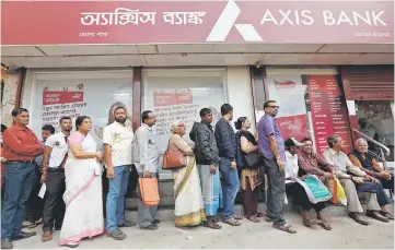  ??  ?? People queue outside a bank to withdraw cash and deposit their old high denominati­on banknotes in Kolkata, India. India can ill-afford to take much pride in having the world’s fastest growing large economy when it releases September quarter data...