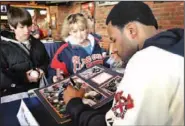 ??  ?? Atlanta Braves right fielder Jason Heyward signs a print for Cindy Flippo and her son Jake Flippo on Thursday during the Braves Caravan visit at Taco Mac.