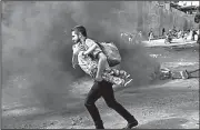  ?? AP/RODRIGO ABD ?? A man and a boy run through smoke at a burning barricade after protests broke out Friday in Tegucigalp­a over the ballot counting in Honduras’ presidenti­al election.