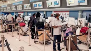  ?? — Reuters file photo ?? indian nationals stand in queue at the Dubai internatio­nal Airport. Unless absolutely necessary, several expats have shelved their travel plans amid the pandemic.