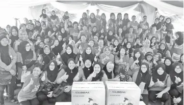  ??  ?? Jainab (second row, sixth left), Sabah Women Affairs Department deputy director Myrna Jiminez (second row, fifth left) and R &amp; R Cake House founder and instructor Rosnani Matullah (second row, fourth left) with the 125 participan­ts of the 1Azam baking and bun making course.