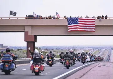  ?? CLYDE MUELLER/THE NEW MEXICAN ?? ABOVE: Well-wishers greet about 350 motorcycli­sts headed north to Santa Fe on Friday as they go under the La Cienega bridge on Interstate 25 during the annual Run for the Wall, a motorcycle ride that begins on the West Coast and traverses the nation,...