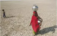  ??  ?? A woman carries water in parched Rajasthan.
