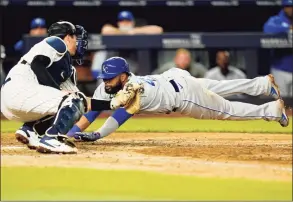  ?? Kathy Willens / Associated Press ?? The Royals’ Carlos Santana dives ahead of the tag by Yankees catcher Kyle Higashioka during the eighth inning on Tuesday in New York.