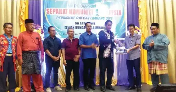  ??  ?? Limbang divisional Informatio­n officer Francis Bunchol (second right) presents a gift to Dr Abdul Rahman. At fifth left is Limbang Walikota Sufian Mohat.