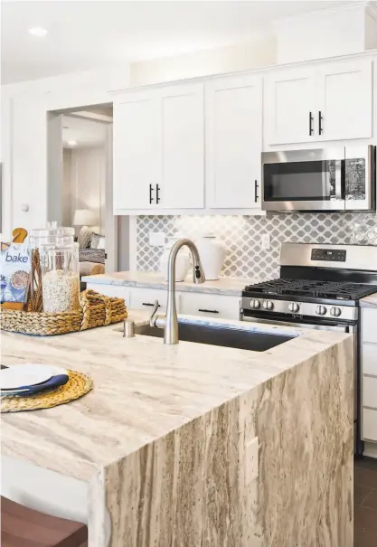  ?? ROCHELLE PETTIT ?? This kitchen features a center island, Shaker cabinetry, and stainless steel appliances which represents the luxury and highend finishes found at Carnelian at Granite Bay by Blue Mountain Communitie­s.