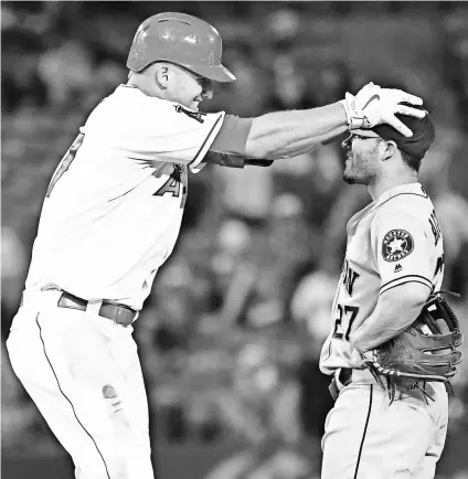  ?? RICHARD MACKSON, USA TODAY SPORTS ?? Despite occasional­ly tripping over second, Mike Trout and Jose Altuve, right, are loving baseball.