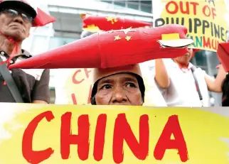  ??  ?? PROTESTORS DISPLAY placards during a rally by left-wing activists outside the Chinese Consulate, to protest Beijing's continued reclamatio­n activities in the South China Sea, in Makati, Metro Manila, Philippine­s, Feb. 10.