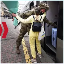  ?? ?? GIVE US A HUG Soldier waits with flowers then embraces returning partner at Kharkiv station yesterday