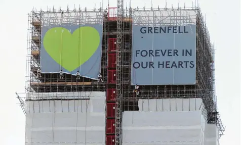  ?? Foto: Yui Mok, dpa ?? Die Banner am Grenfell Tower sollen an die Brandkatas­trophe vor einem Jahr erinnern.