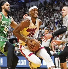  ?? LYNNE SLADKY/AP ?? Heat forward Jimmy Butler, who had a game-high 41 points in the 118-107 win, drives to the basket between Celtics guard Derrick White (9) and center Daniel Theis during the second half of Game 1 of the Eastern Conference finals Tuesday in Miami.